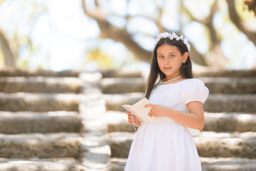 Niña vestida de comunión en bosque