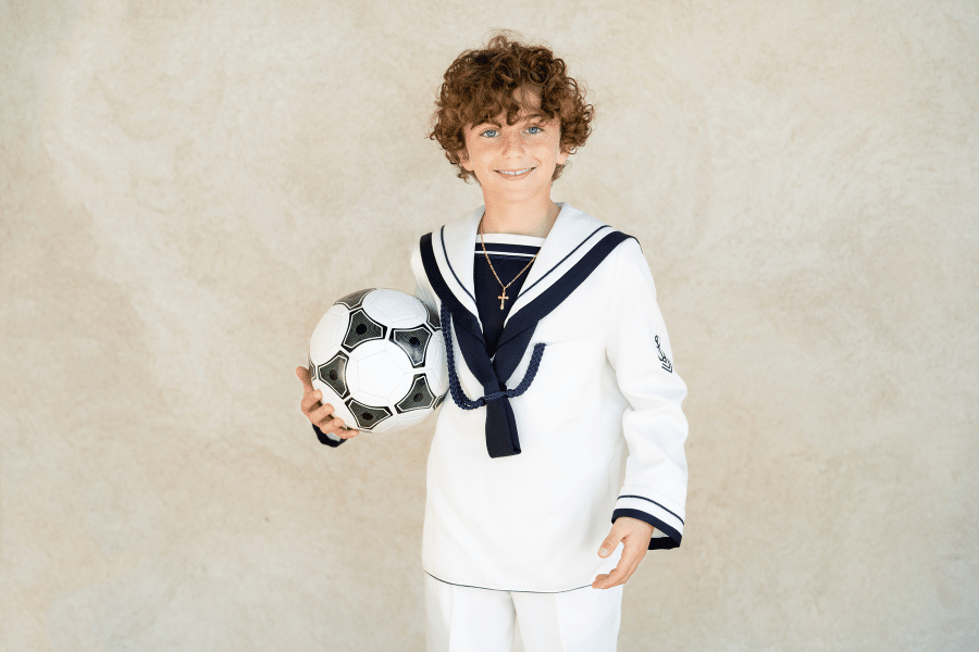 Niño vestido de comunión con pelota